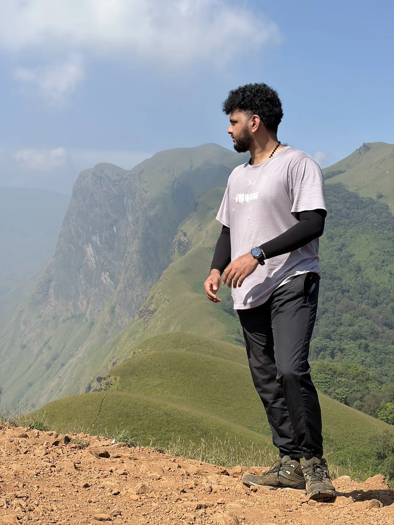 Alvin hiking on a mountain ridge overlooking green valleys